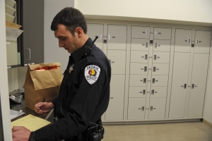 Police officer checking in evidence to the short-term evidence lockers